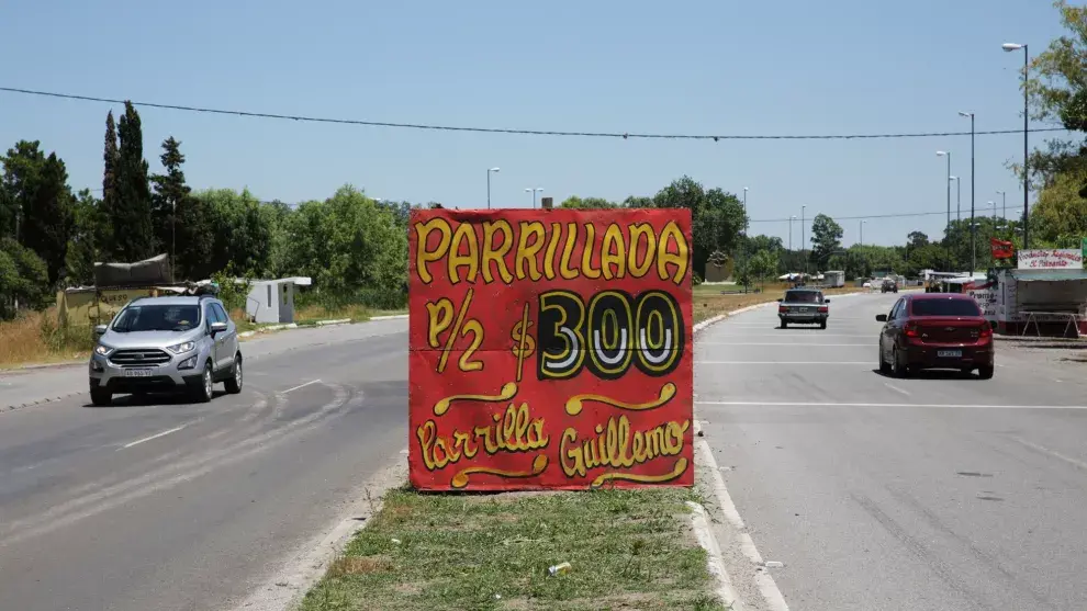 Uno de los tradicionales carteles sobre la ruta para ofrecer parrillada al paso