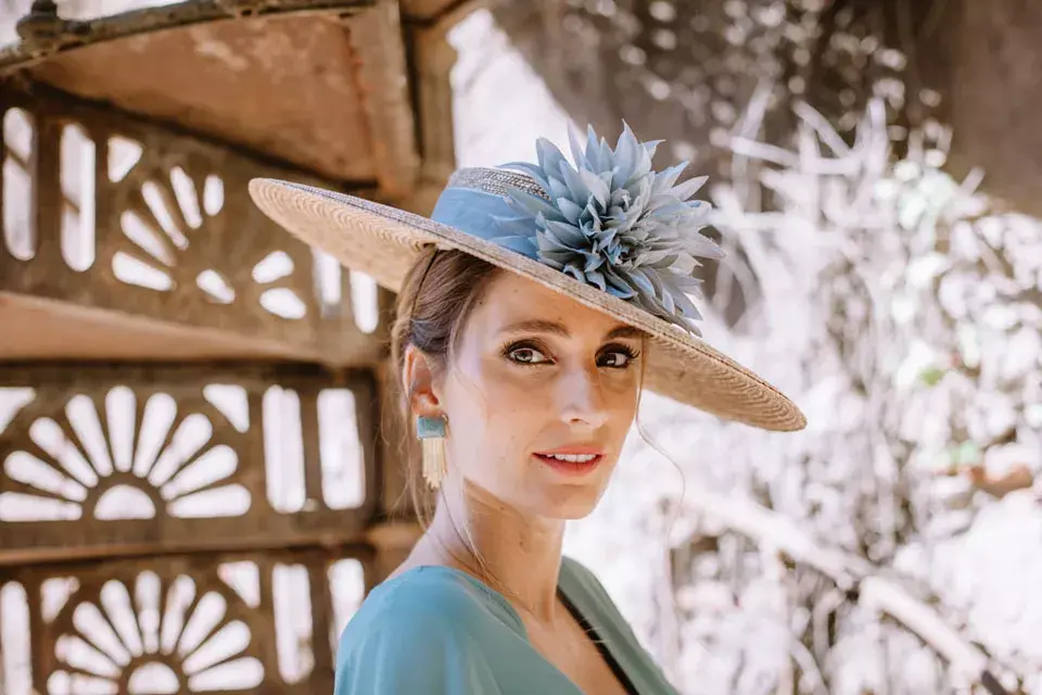 Sombrero con tocado y mega aros para un look de invitada ideal