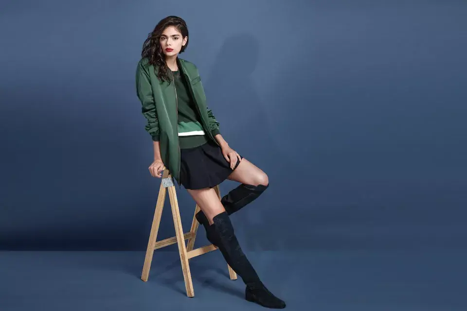 La campera aviadora se lleva oversize. Campera (Chocolate), suéter y falda (Lacoste), bucaneras (Vitamina)