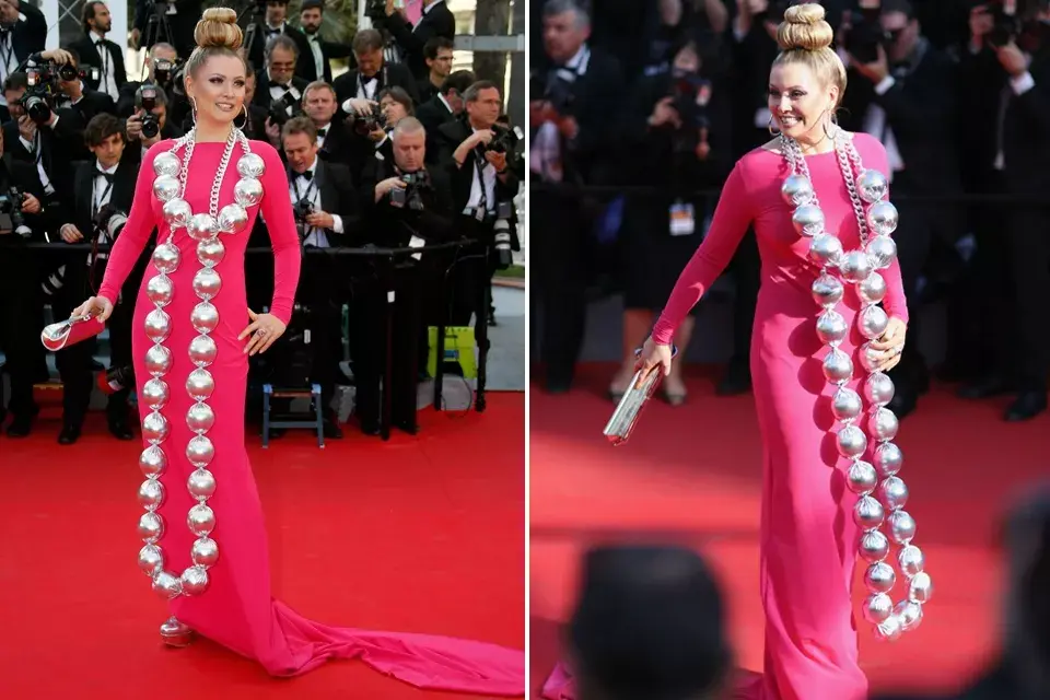 La actriz rusa, Elena Lenina, lució un vestido al cuerpo con cola en color fucsia y como accesorio optó por un collar con mega borlas en color plateado. Para coronar este llamativo look eligió un maxi knit knot como peinado ¡De terror!