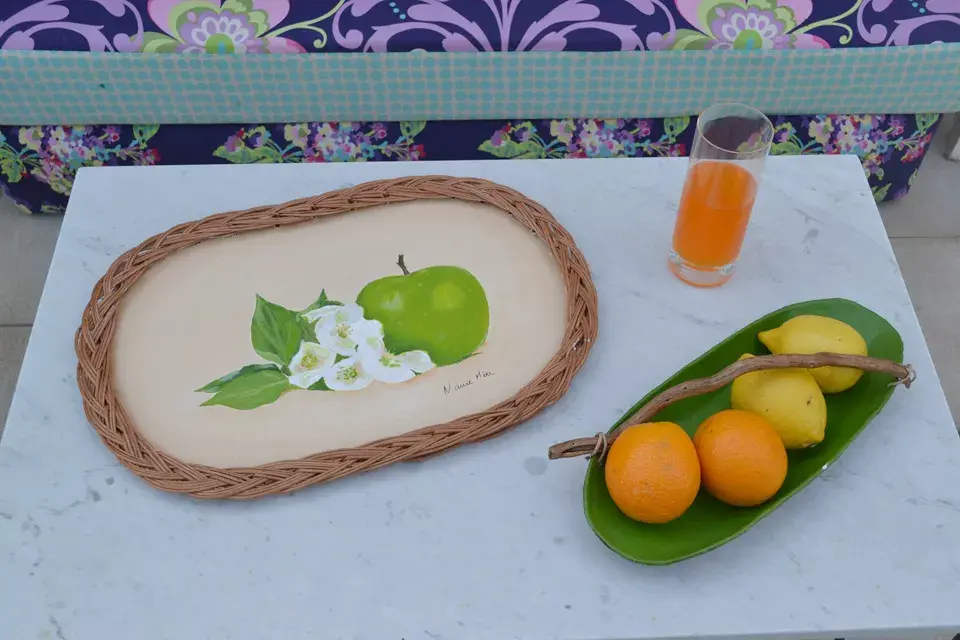 Los colores intensos también se trasladaron a la mesa baja que propone un menú natural con frutas y jugos coloridos. Bandeja de madera con borde de mimbre ($120) y centro de mesa en papel maché ($150, todo Nana mía) que acompaña el concepto general de la propuesta