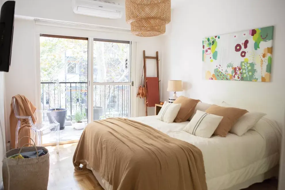 Detalles que hacen al conjunto: ropa de cama (Josephine Deco), lámpara (Belgika Home), escalerita de madera (El Postigo) con manta de gasa de algodón (Paysana) y cuadro de la artista Josefina Barba. 