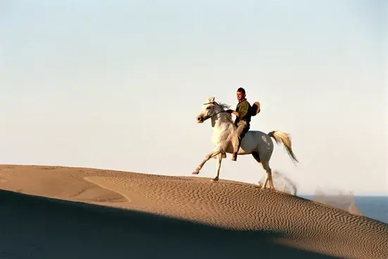 Roberto Bubas cabalgando entre las dunas con su fiel amigo Rigel. Foto: Andrés Bonetti.