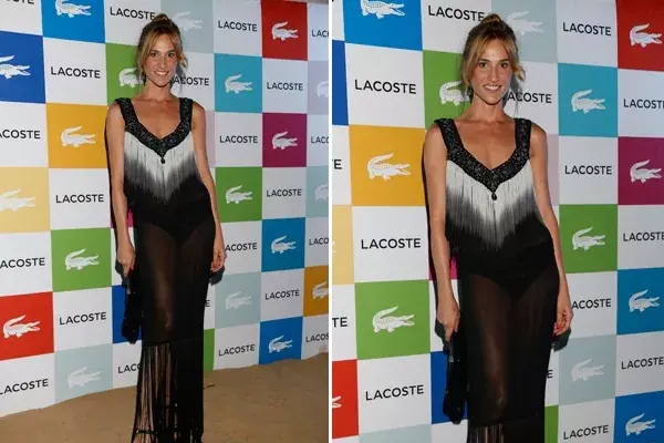 Lara Bernasconi con un vestido largo en blanco, negro y gris con muchos flecos y clutch a tono