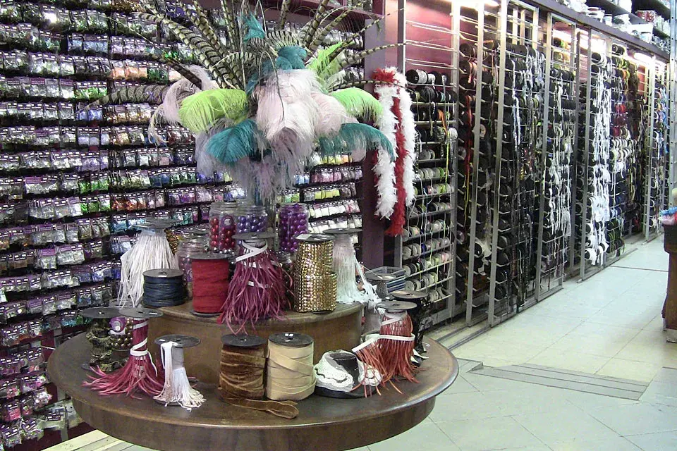 El local tiene la pared cubierta de productos, como mostacillas, cintas, galones y botones