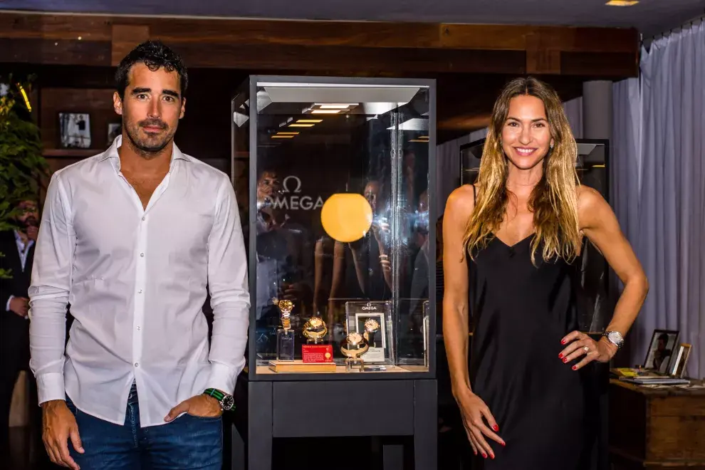 Nacho Viale, con camisa slim fit y jean, Y Andrea Bursten, con un slip dress negro, en un evento de los nuevos modelos de relojes Omega