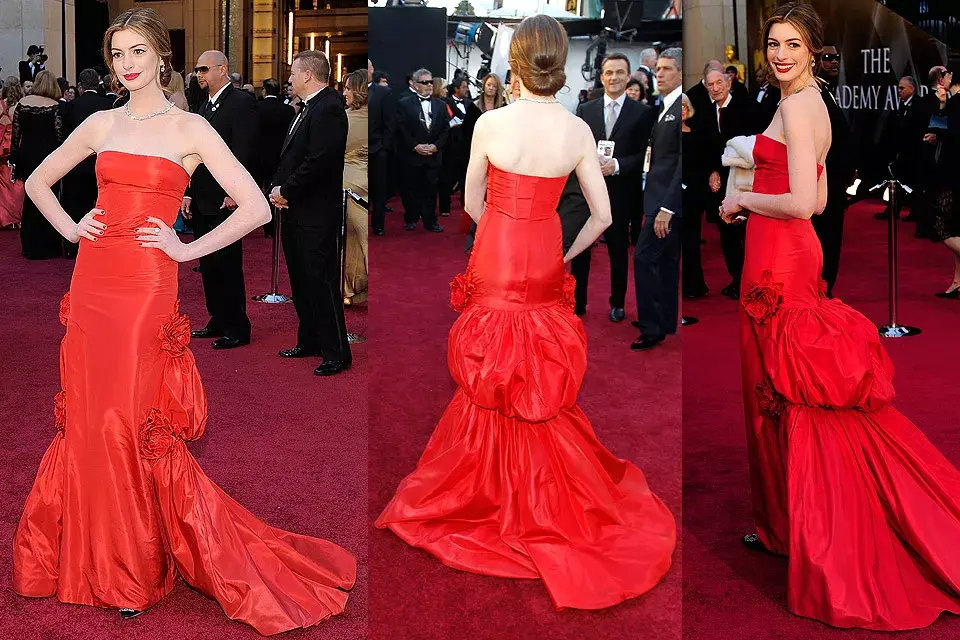 Anne Hathaway usó un strapless de Valentino en tafeta colorada (bien Valentino) para desfilar por la alfombra roja; el diseño con apliques de género y flores a los costados, no convenció