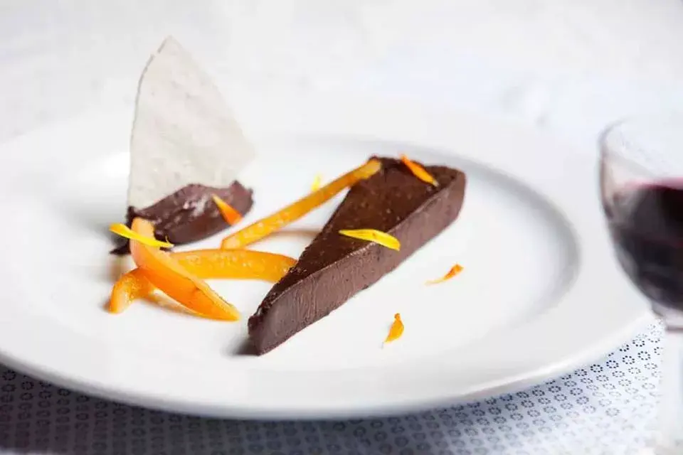 Chocolate húmedo + ganache de chocolate + confitura de naranja + teja de merengue