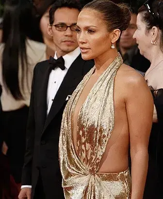 Jennifer López, súper sexy, con un vestido escotado dorado.