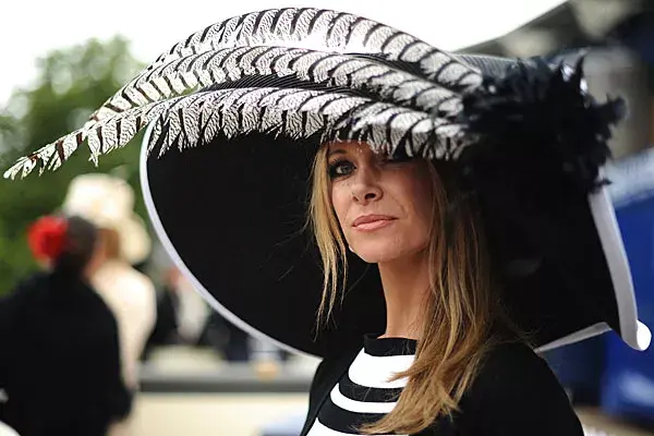 Un sombrero bien amplio, en negro y blanco y con plumas en la parte delantera