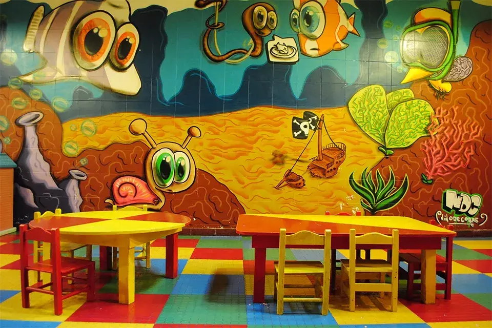 Sala con juegos didácticos, disfraces, juegos de mesa, pizarrón y películas infantiles