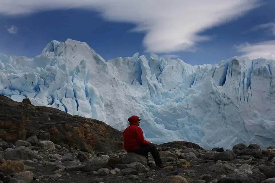 Un hombre observa, abstraido de lo que ocurre su alrededor, lo maravilloso de la imponencia del glaciar