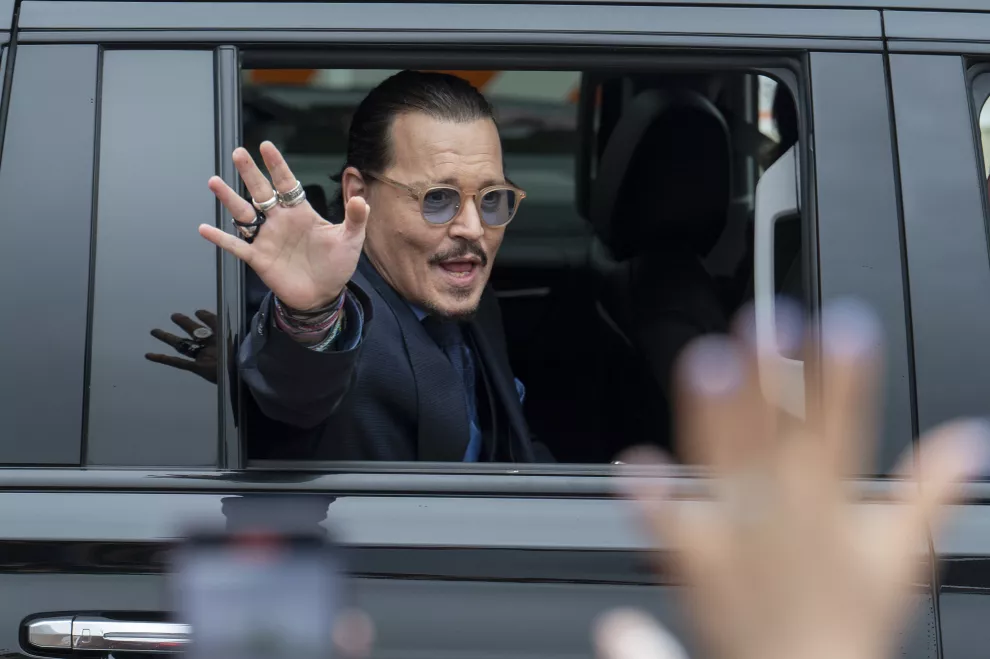 El actor Johnny Depp saluda a sus seguidores al salir del Tribunal. (Foto AP/Craig Hudson)
