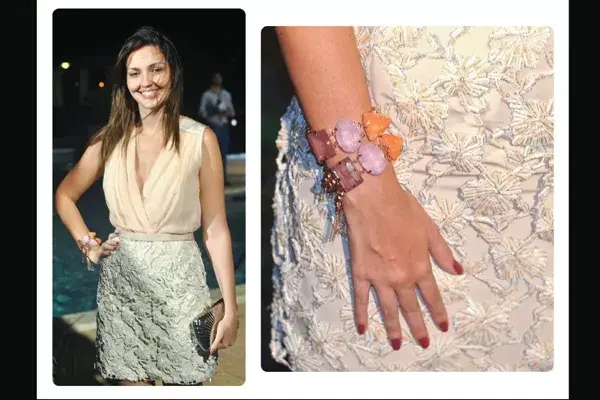 Falda de raso con bordado de canutillos, camisa con escote y sin mangas de seda. Todo en tono off white; las pulseras de piedras lilas y naranjas resaltan sobre el conjunto