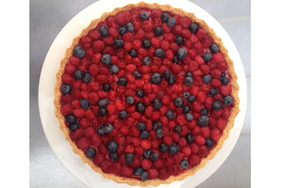 Una tarta con arándanos de ambos colores