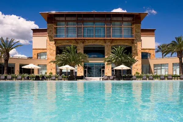 La pileta deh hotel, imponente, rodeada de palmeras