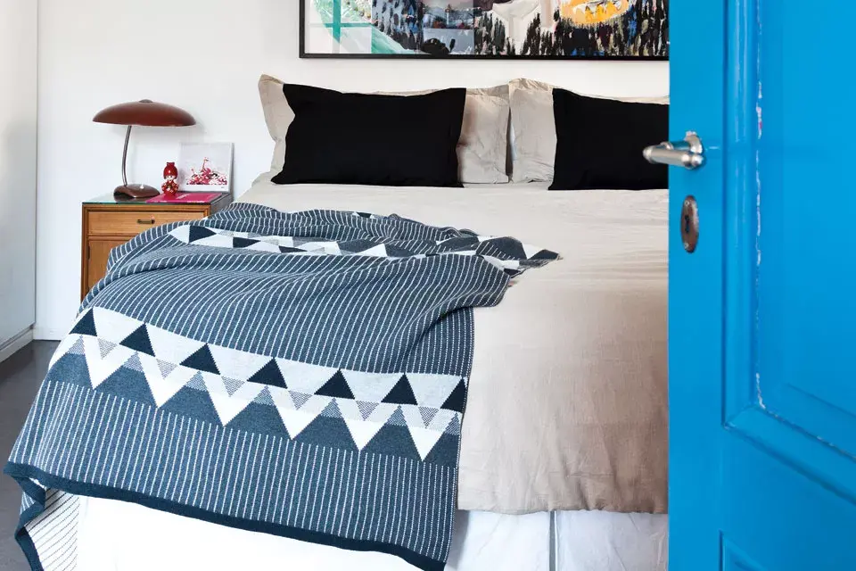 La cama vestida con fundón 100% de algodón panamá con pestañas de 60 x 70 cm ($189), funda nórdica de lino ($2699) y manta tejida zigzag de 1,30 x 1,80 m ($1499, todo Arredo).