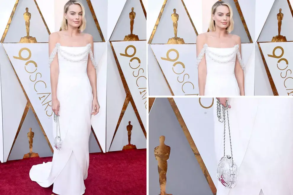 Margot Robbie optó por un vestido blanco con hombros al aire, tirantes caídos con brillos en forma de pétalos