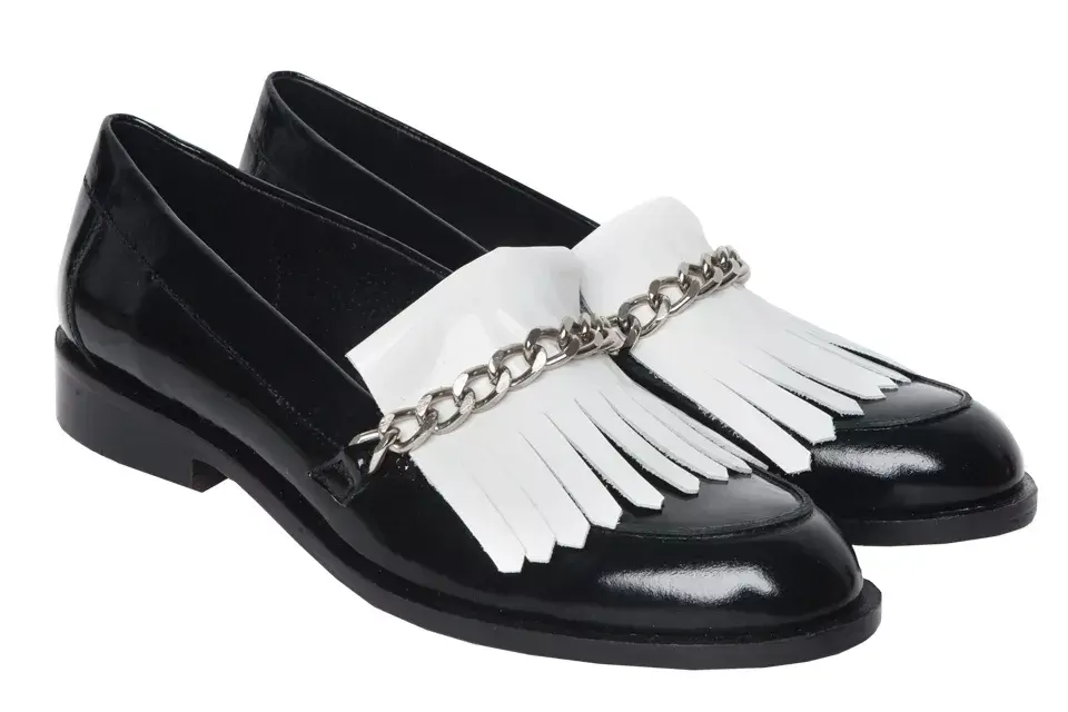 Mocasines chatos en blanco y negro con flecos y cadena, de Prüne