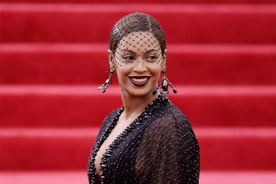 Beyoncé cubrió su rodete tirante con un velo y sumó unos aros divinos de Lorraine Schwartz. Todo eso más los labios bordó, ¿no será demasiado?