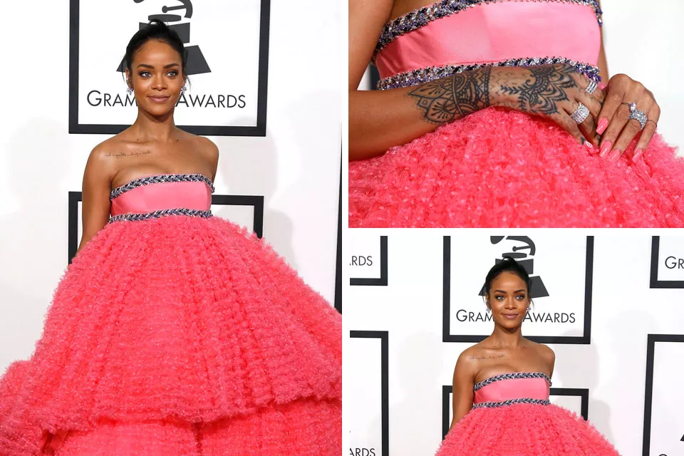 Rihanna optó por un peinado recogido muy simple para poner el acento sobre sus accesorios: uñas de color rosa extra large, anillos de brillantes y tatuajes en su mano izquierda
