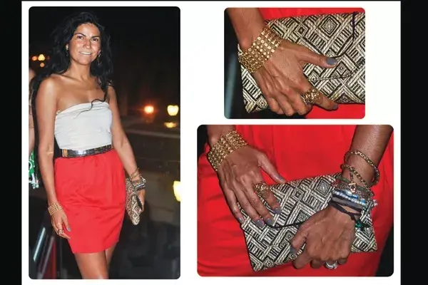 Un clutch de rafia, cinturón metálico y pulseras de cadenas son los accesorios elegidos para combinar con esta falda rojo fuego y strapless blanco