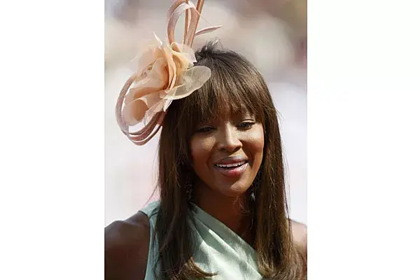 Con el pelo suelto y flequillo, Naomi Campbell optó por usar una gran flor en color natural