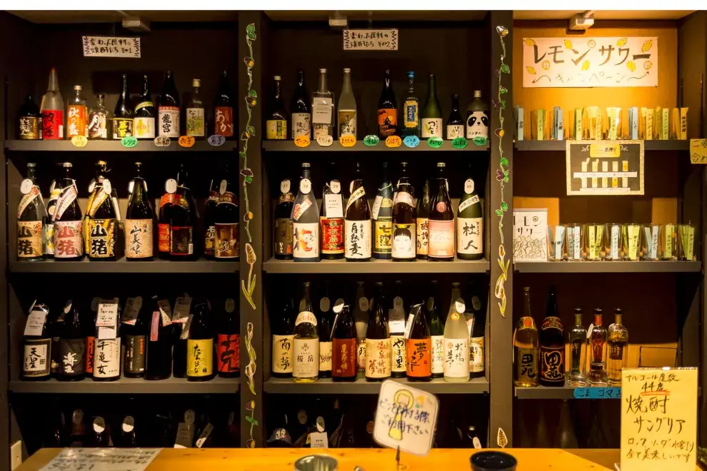 Una estantería de shochu, con botellas de todos los colores