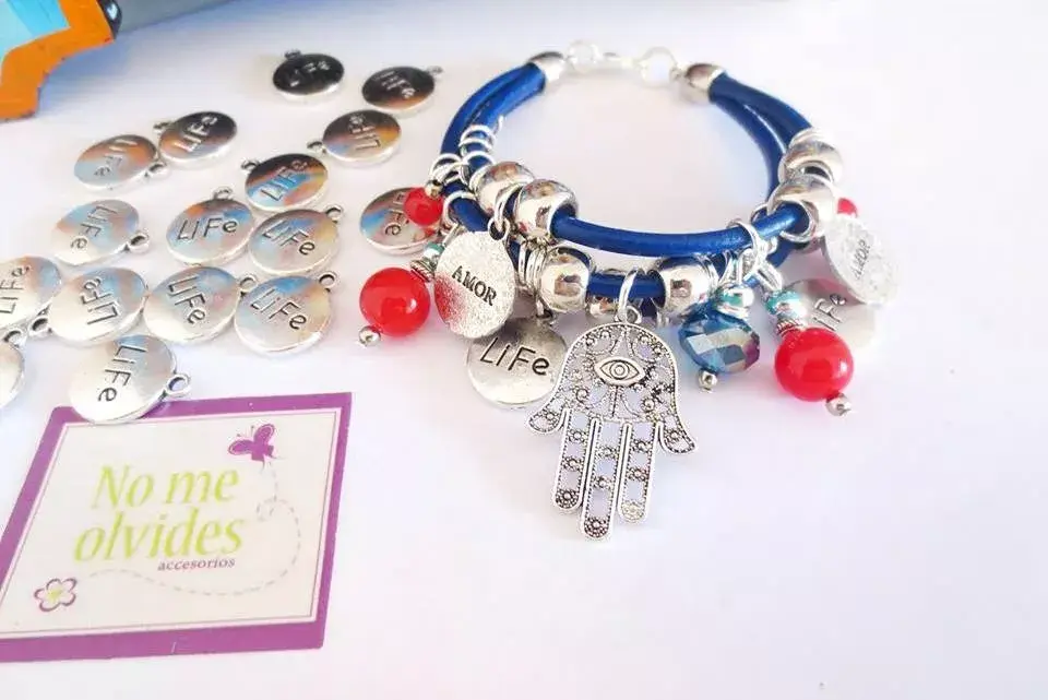 Pulsera Life, de cuero azul con dijes en tonos plata y piedras rojas ($180, No Me Olvides Accesorios)