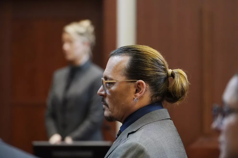 Los actores Johnny Depp, al frente, y Amber Heard comparecen en el Tribunal de Circuito del Condado de Fairfax, en Fairfax, Virginia, el jueves 5 de mayo de 2022 (Foto AP/Steve Helber, Pool)