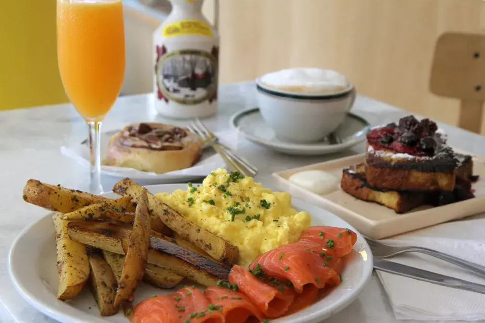 El brunch Clásico con huevo revuelto, salmón y papas al horno, entre otras cosas