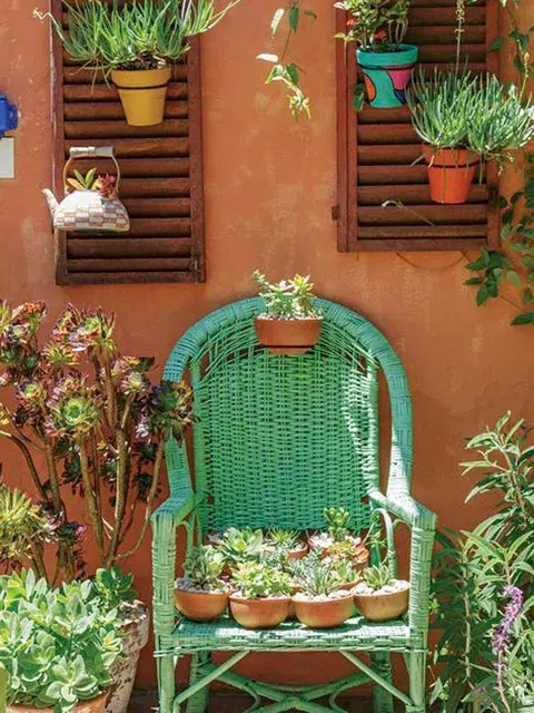 Macetas pintadas a mano y un sillón de mimbre renovado con pintura brillante