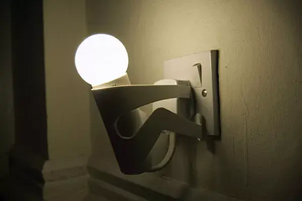 Una luz de noche con forma de hombrecito que queda divina en la pared