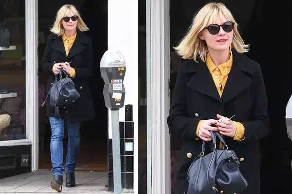 Kristen Dunst prefiere el estilo sencillo: jean, botas de falso taco chino, tapado y cartera baulito; ¿qué opinan de la camisa color mostaza?