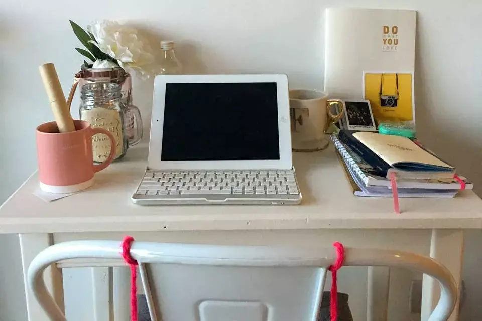 Las superficies blancas (escritorio, paredes y silla) mechadas con algunos toques en colores pastel, vuelven muy femenino este espacio. Poner flores en un jarrón chiquito también es una gran forma de alegrar tu lugar de trabajo