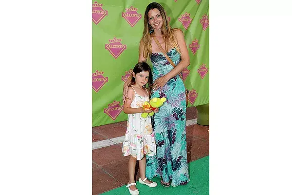 Con un solero largo de estampa floreada en la gama del turquesa, Geraldine Neumann llevó a su hija a ver el show de Adriana