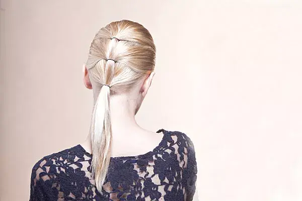 COLITAS EN SECUENCIA:  Primero, dividí la parte superior del pelo y atalo con una gomita (preferentemente, de las chiquitas). Después, dividí el pelo a la altura de la mitad de la oreja, incorporá la colita que quedó arriba y sujetalo con otra gomita. Ahora, con todo el pelo, atá la última gomita a