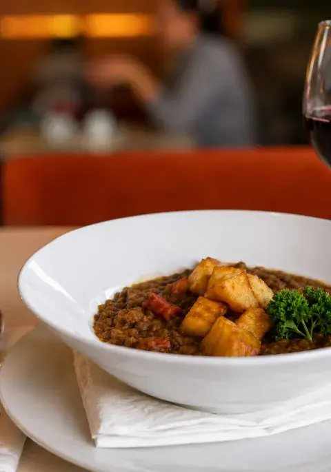 guiso de lentejas y copa de vino