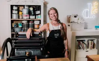 Sabrina Poy, entre sus máquinas antiguas y sus tintas en su taller y showroom de Rosario.