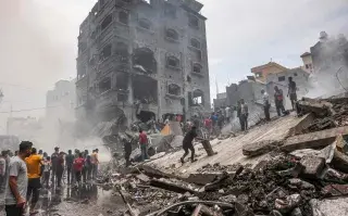 Palestinos buscan supervivientes después de un ataque aéreo israelí contra edificios en el campo de refugiados de Jabalia, en la Franja de Gaza, el 9 de octubre de 2023.