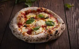 La pizza napolitana se caracteriza por tener una masa fina pero esponjosa, con un borde alto, aireado y crujiente.