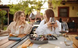 Amigas en una terraza celebrando.