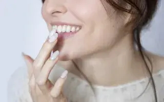 Mujer tocándose los labios con las manos