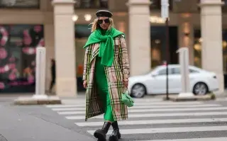 Mujer caminando con trench por la calle.