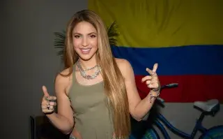 Fotografía de Shakira junto a la bandera de Colombia.