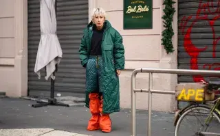 Looks de invierno para un día de lluvia inspirados en el street style Mujer con pilota para lluvia y botas
