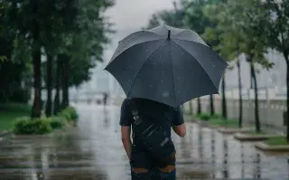 Hombre usando un paraguas debajo de la lluvia