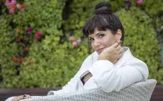 Griselda Siciliani sentada en un sillón en el jardín de su casa y rodeada de plantas