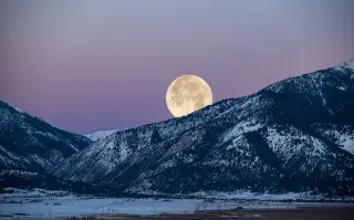 Luna llena sobre unas montañas