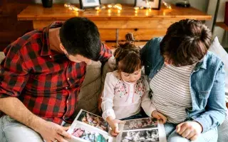Constelaciones familiares: cómo puede ayudarte en el vínculo con tus hijos Familia viendo un álbum de fotos